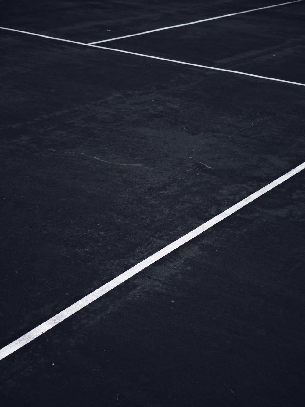 Close-up of freshly painted white parking lot line striping on dark asphalt